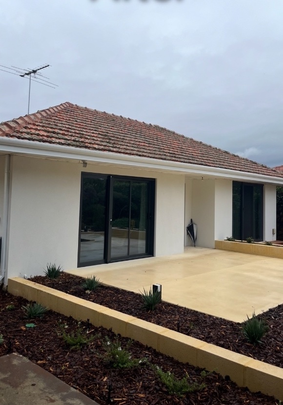 After: The same roof repaired, with straight tile edges, new fascia and new white gutters