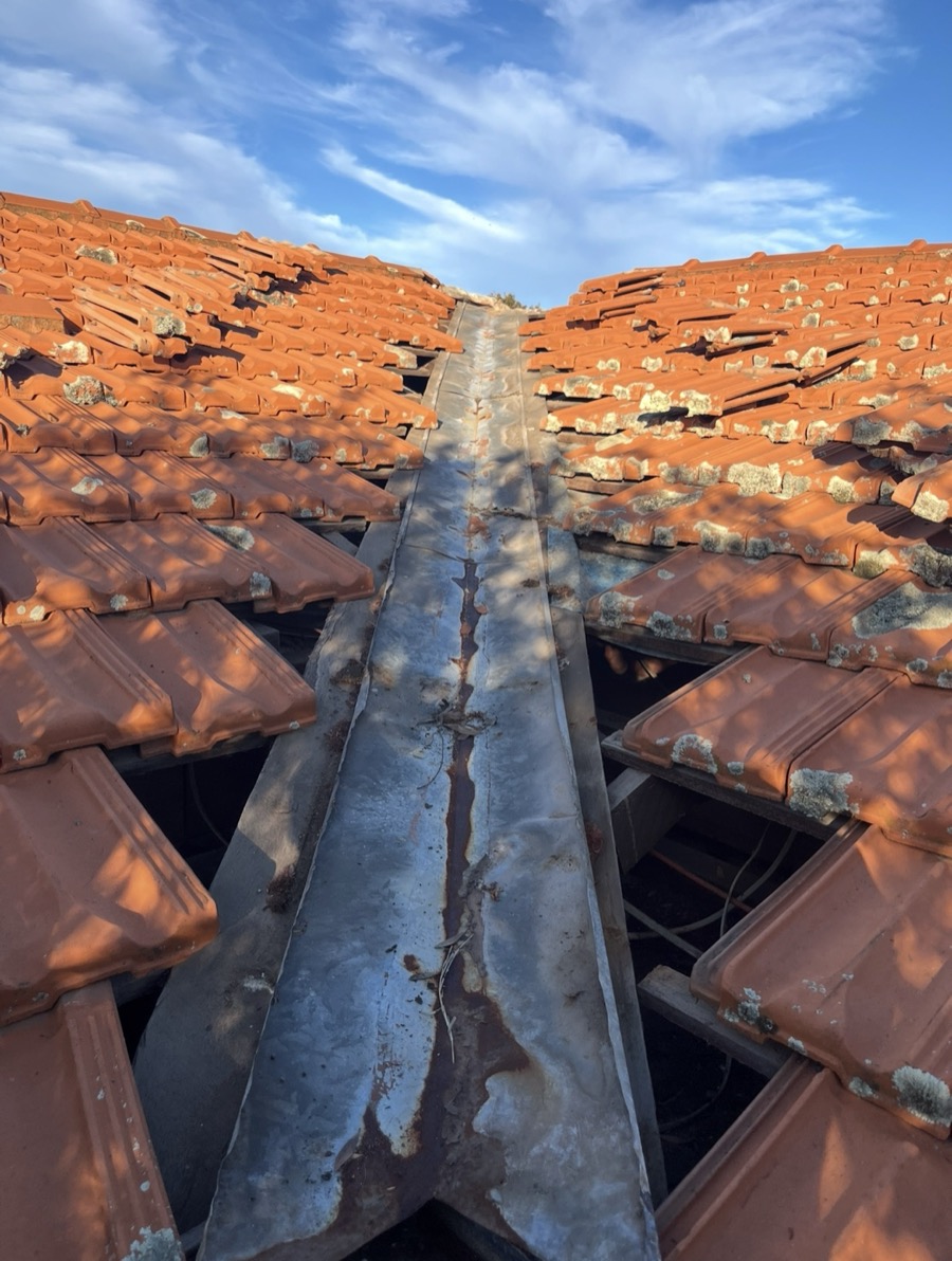 Before: Rusted, patched valley iron with tiles lifted on both sides