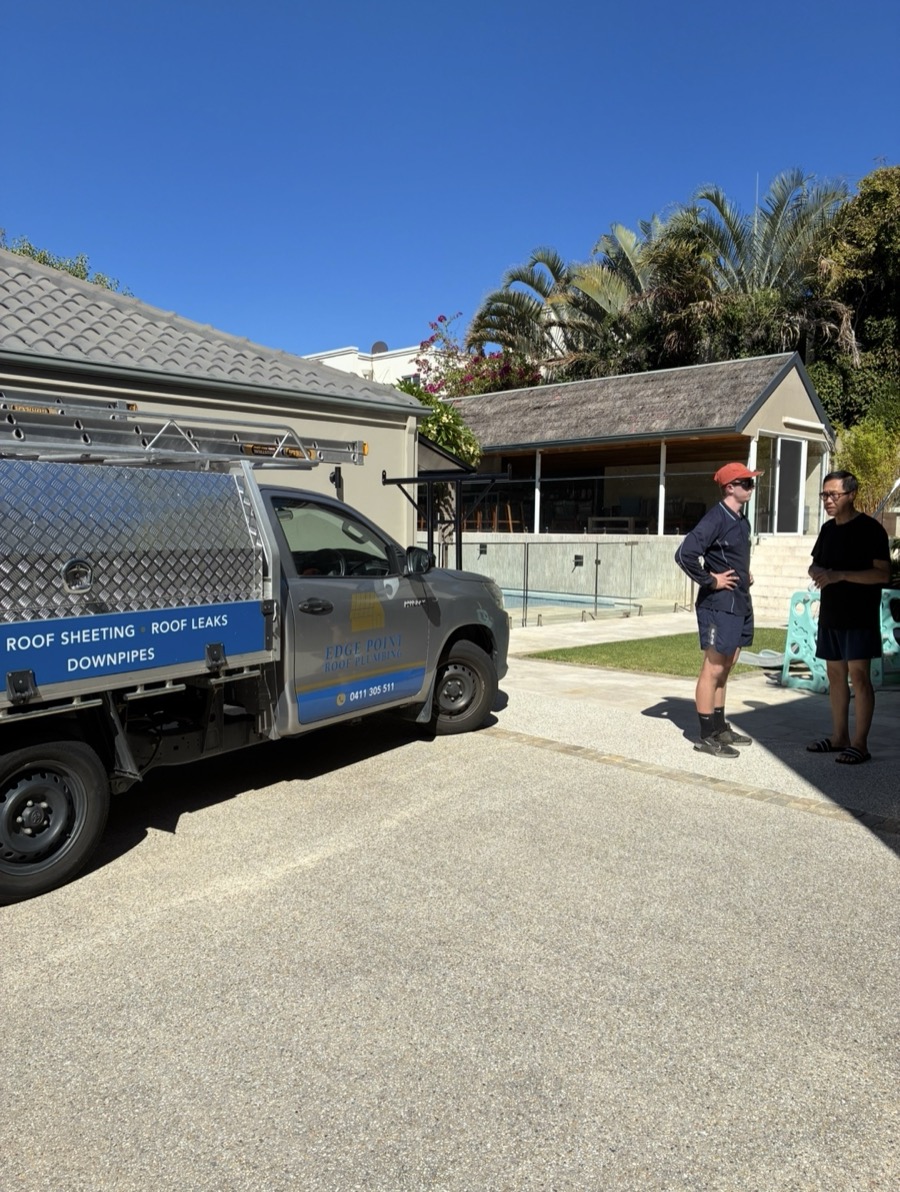 An Edge Point roof plumber talking through a job with a customer beside the Edge Point ute