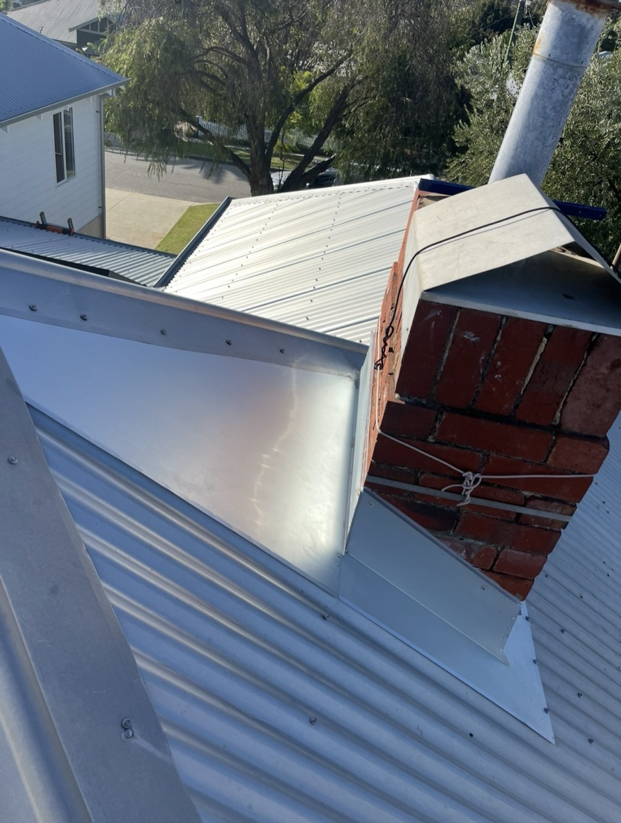 New chimney flashings and back gutter on a metal roof
