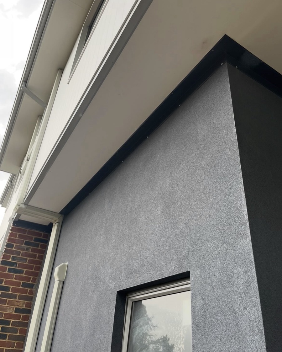 Flashings and downpipes on a rendered two-storey home