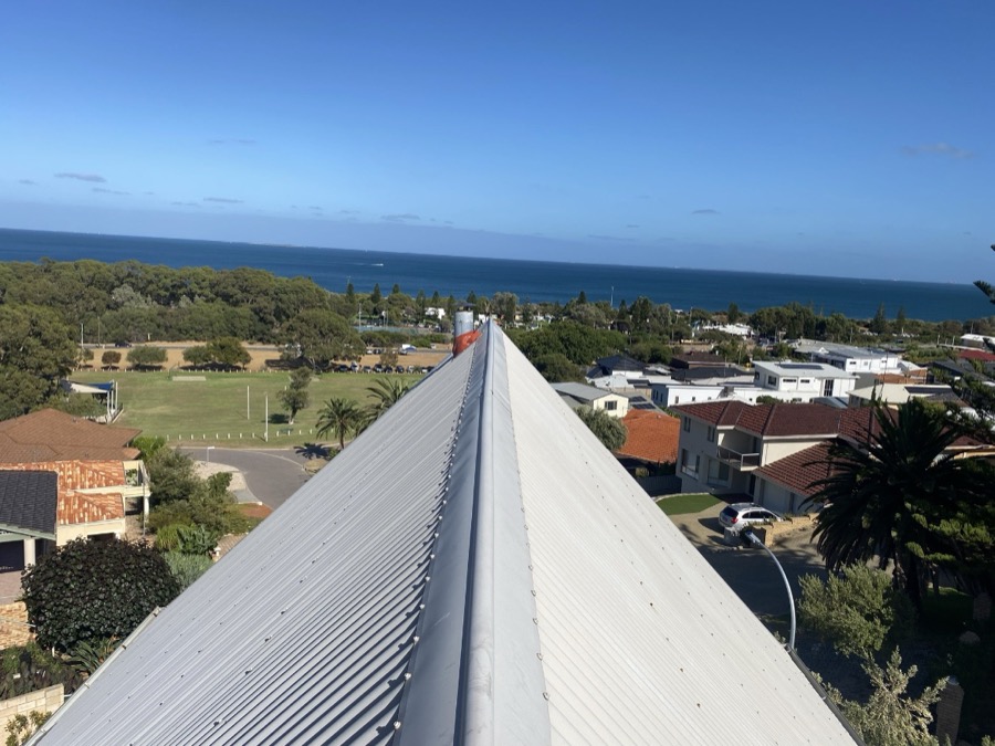 New ridge capping on a metal roof, with ocean views